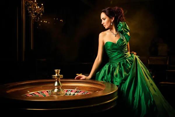 A stylish woman beside vibrant slot machines displaying glowing sevens, showcasing the variety of top slots at SPORTYBEF.